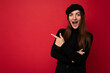 Portrait of beautiful fascinating emotional positive joyful happpy female promoter pointing to the side at copy space for advertising wearing hipster outfit isolated over background wall with empty