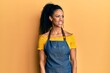 Middle age african american woman wearing professional apron smiling looking to the side and staring away thinking.