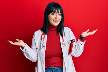 Poster - Young hispanic woman wearing doctor uniform and stethoscope smiling showing both hands open palms, presenting and advertising comparison and balance