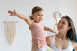 © Вадим Каштанов - Young mother with little daughter practice yoga home. Warrior pose.
