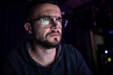 Wall Mural - A man stares intently at a computer screen in the dark at night.