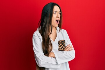 Sticker - Young hispanic girl with arms crossed gesture angry and mad screaming frustrated and furious, shouting with anger. rage and aggressive concept.