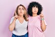 © Krakenimages.com - Middle east mother and daughter wearing casual clothes pointing up looking sad and upset, indicating direction with fingers, unhappy and depressed.