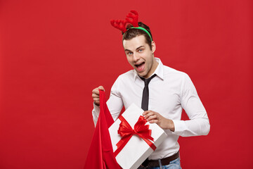 Christmas Concept - Handsome Business man celebrate merry christmas and happy new year wear reindeer hairband holding Santa red big bag.