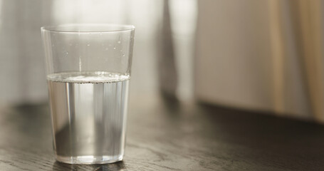 Sticker - sparkling water in tumbler glass on black oak table with copy space