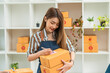 Young asian girl is freelancer Start up small business owner writing address on cardboard box at workplace,Shipping shopping online small business entrepreneur SME or freelance