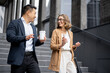 © rh2010 - Asian businessman and caucasian businesswoman walking and talking on stairs in city. Concept of business cooperation. Idea of freelance and remote work. Modern successful business people with coffee