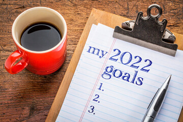 Wall Mural - my 2022 goals list on clipboard and coffee against grunge wood desk, setting New Year goals and resolutions