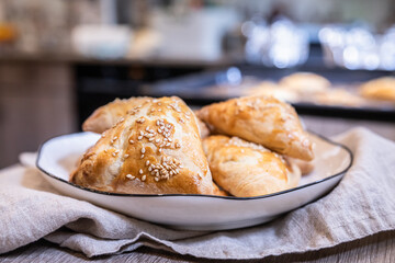 Wall Mural - Puff pastry buns with pumpkin sprinkled with sesame seeds. Homemade autumn pastries.