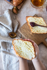 Wall Mural - The child is holding a croissant cut in half. Delicious homemade croissant cutaway. Top view.