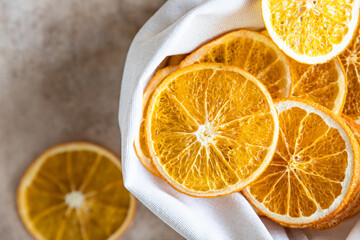 Wall Mural - Organic dried orange chips in eco canvas bag on light concrete background. Top view.