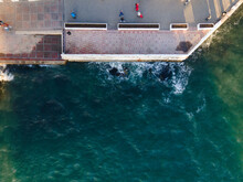 Stormy Sea On The Embankment Of The City From A Bird's Eye View. Foamy White Waves Hit The Dock. Black Sea.