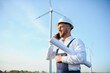 © Serhii - Engineer in wheat field checking on turbine production