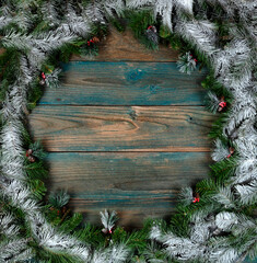 Canvas Print - Top view of a snow covered wreath with pine cone ornaments in circle border on blue aged wooden planks for the winter holiday season of Christmas or New Year background