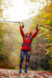 © Nikola Spasenoski - Hiking girl with poles and backpack on a trail. Hands up enjoying in nature. Travel and healthy lifestyle outdoors in fall season.