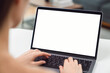 © sitthiphong - Woman hand using laptop and sitting on the table in the house, mock-up of a blank screen for the application.
