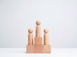© tete_escape - Business competition winner. The wooden figure standing on the winner podium, wood cube block on white background with copy space, minimal style. Goals, success, and leadership concept.