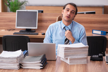 Young male employee unhappy with excessive work