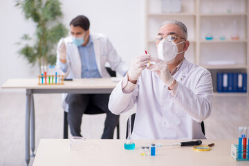 Two male chemists working at the lab during pandemic