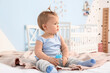 © Pixel-Shot - Cute baby girl with bottle of water in bedroom