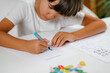 © Microgen - Child coloring shapes in a preschool assessment test.