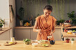 © pressmaster - Happy housewife sprinkling homemade smoothie in bowl with coconut flakes