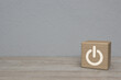 Power button icon on wood block cube on wooden table over white wall background, Start up business concept