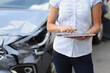 Female insurance agent enters data into car damage program