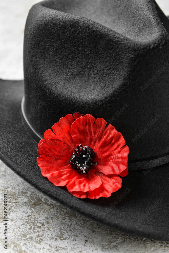 Poppy flower with hat on grunge background, closeup. Remembrance Day, closeup