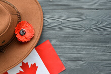 Poppy Flower With Hat And Flag Of Canada On Wooden Background. Remembrance Day