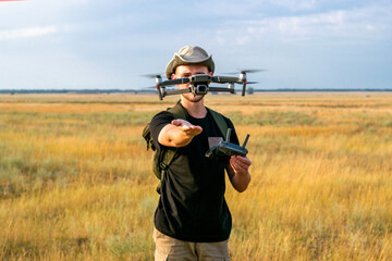 a tourist guy launches a quadcopter with his hand in front of him