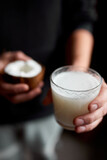 Fototapeta Morze - Male hands with glasse of vegan coconut milk, Alternative types of non-dairy milks, plant milk made of various grain, Clean eating, Healthy diet..