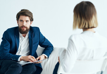 Wall Mural - A man sits on a sofa next to a patient visiting a psychologist problems therapy