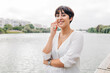 © Westend61 - Beautiful woman with short hair standing by lake