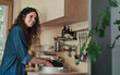 © Halfpoint - Happy young woman washing up indoors in a tree house.