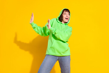 Canvas Print - Photo of positive happy nice young woman dance raise hands look empty space isolated on yellow color background