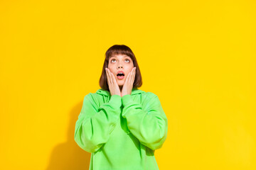 Sticker - Portrait of attractive amazed girl looking up copy empty blank space isolated over bright yellow color background