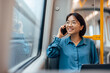 Portrait of a smiling asian businesswoman in public transport.