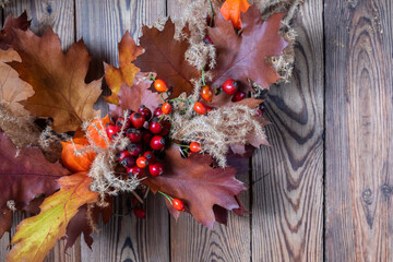 Closeup dried floral wreath from natural materials on dark wooden background. Autumn home decor concept