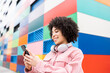 © VISTA by Westend61 - Smiling woman with headphones using mobile phone