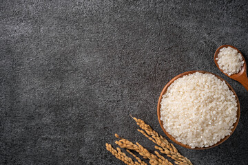 Wall Mural - White rice in a bowl on dark black table background.