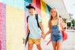 © VISTA by Westend61 - Friends holding hands while walking by wall