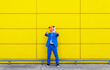 © VISTA by Westend61 - Man wearing vibrant blue suit and tiger mask showing two middle fingers in front of yellow wall