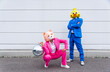 © VISTA by Westend61 - Man and woman wearing vibrant suits and animal masks posing with disco ball in front of white wall