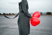 Mid Adult Woman Holding Balloon On Road