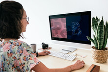 Female Designer Using Computer In Light Studio