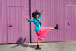 © VISTA by Westend61 - Carefree young woman dancing in front of purple cabin