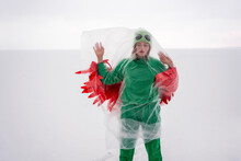 Woman Wearing Bird Costume Wrapped In Plastic Against Sky