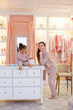 © Elena  - caucasian mother and african american daughter in pink pajamas in dressing room and bedroom