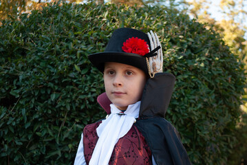 Wall Mural - a boy in a witcher vampire costume against the background of the city of the bush on Halloween